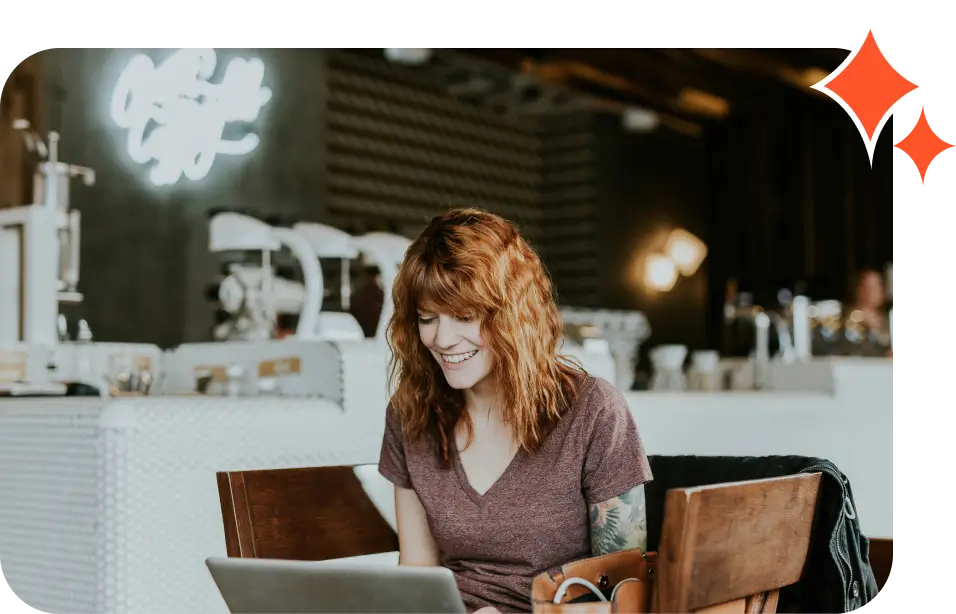 A woman sitting at a table with her laptop.