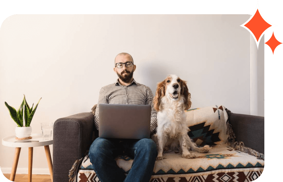 A man sitting on top of a couch with his laptop.